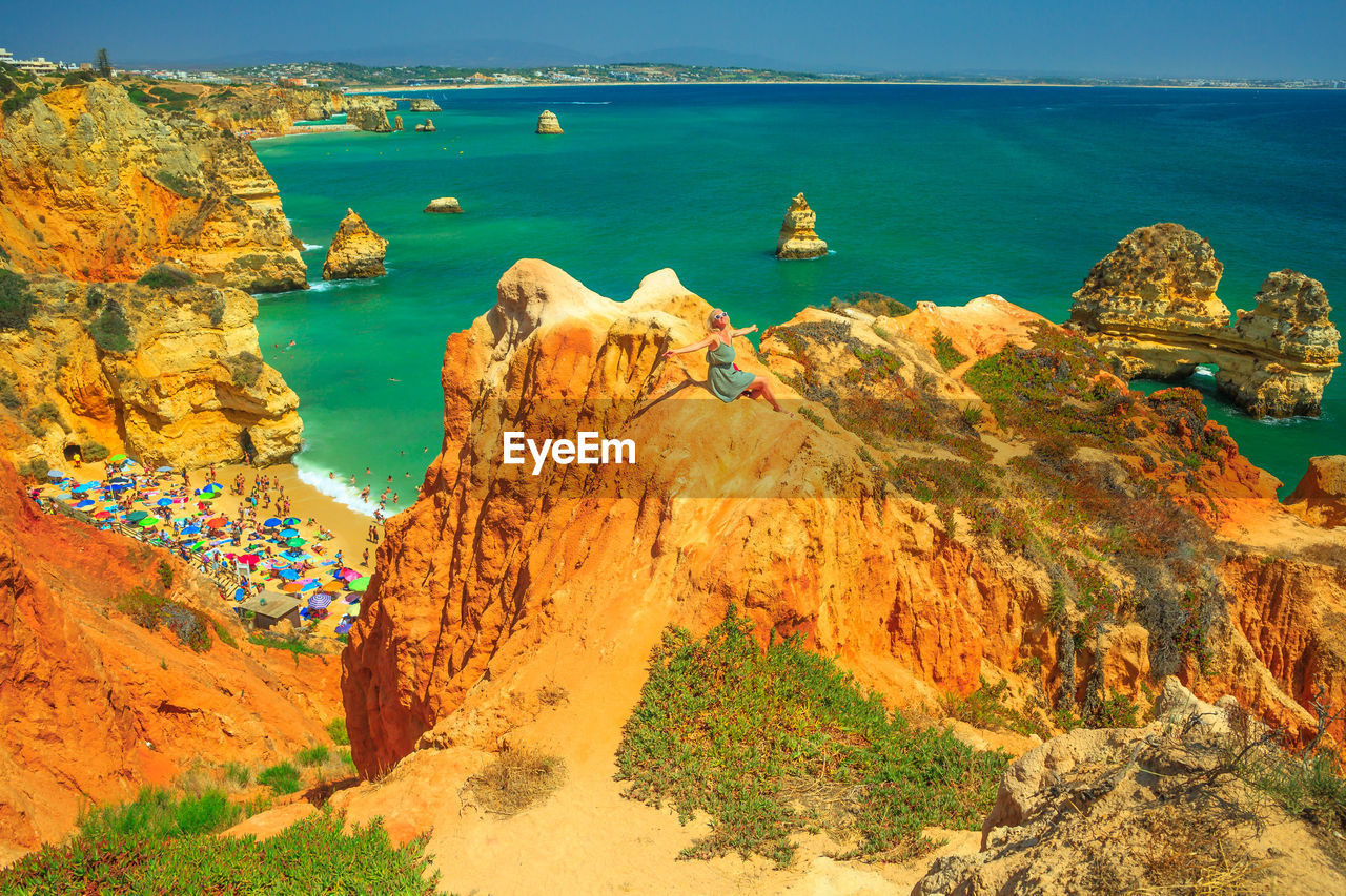 High angle view of woman sitting on rock against sea