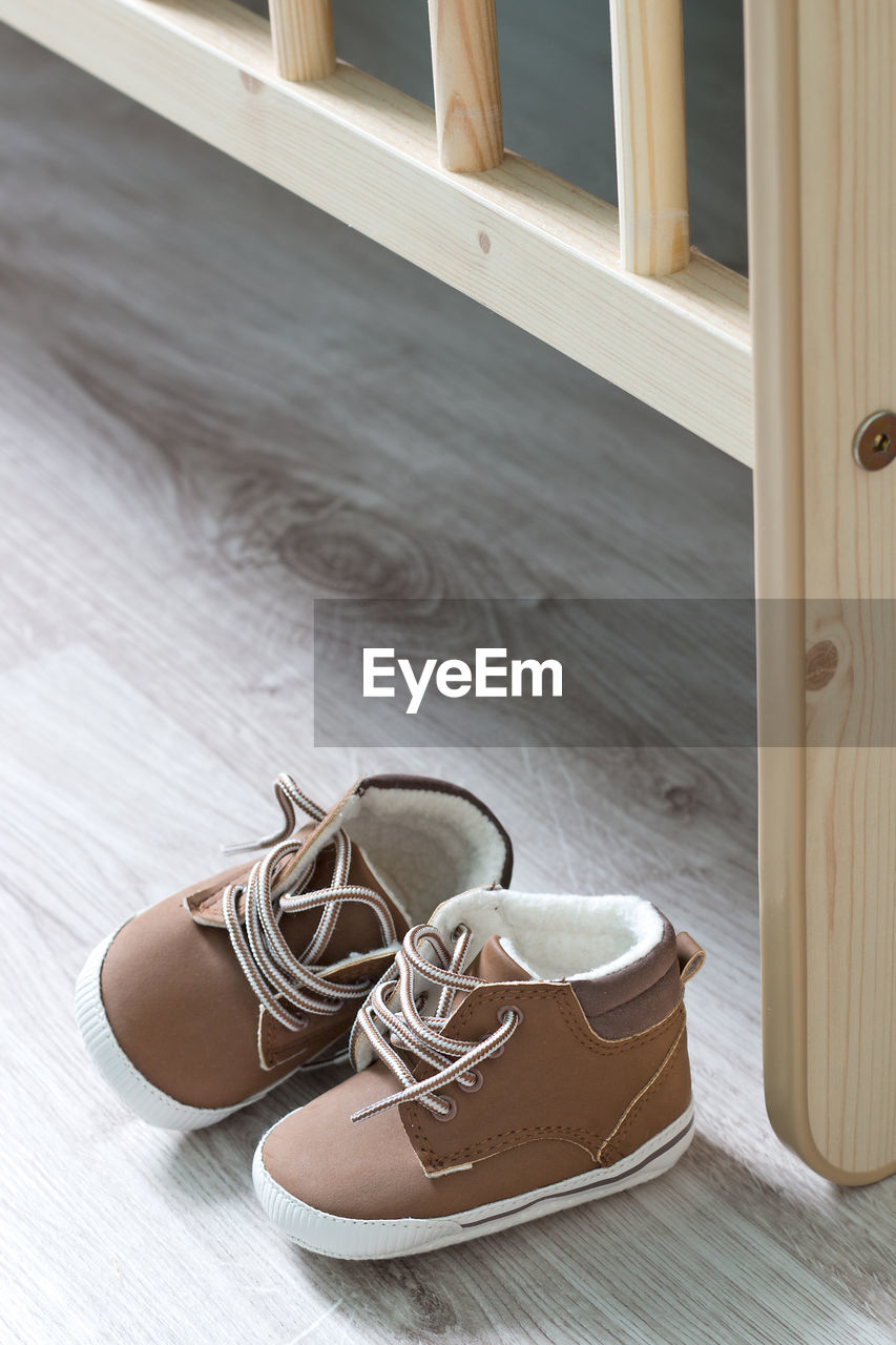 CLOSE-UP OF SHOES ON WOODEN FLOOR