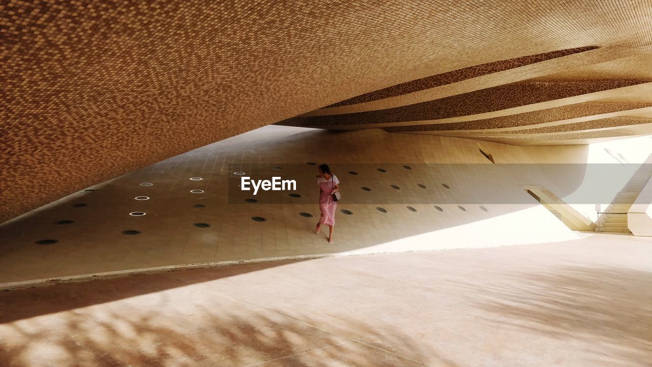 HIGH ANGLE VIEW OF WOMAN WALKING ON STREET