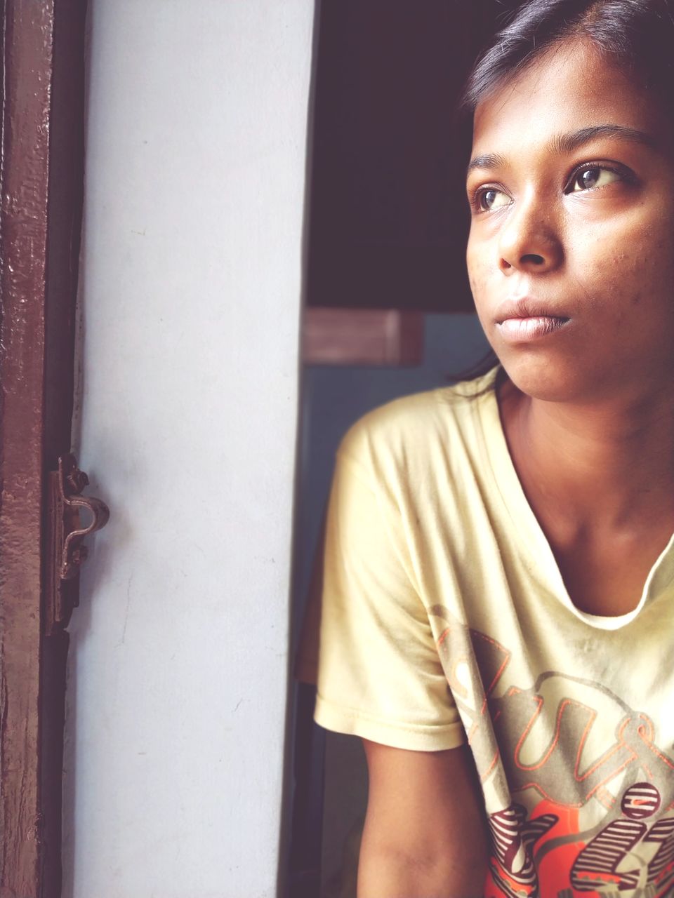 Close-up of thoughtful teenage girl looking away at home