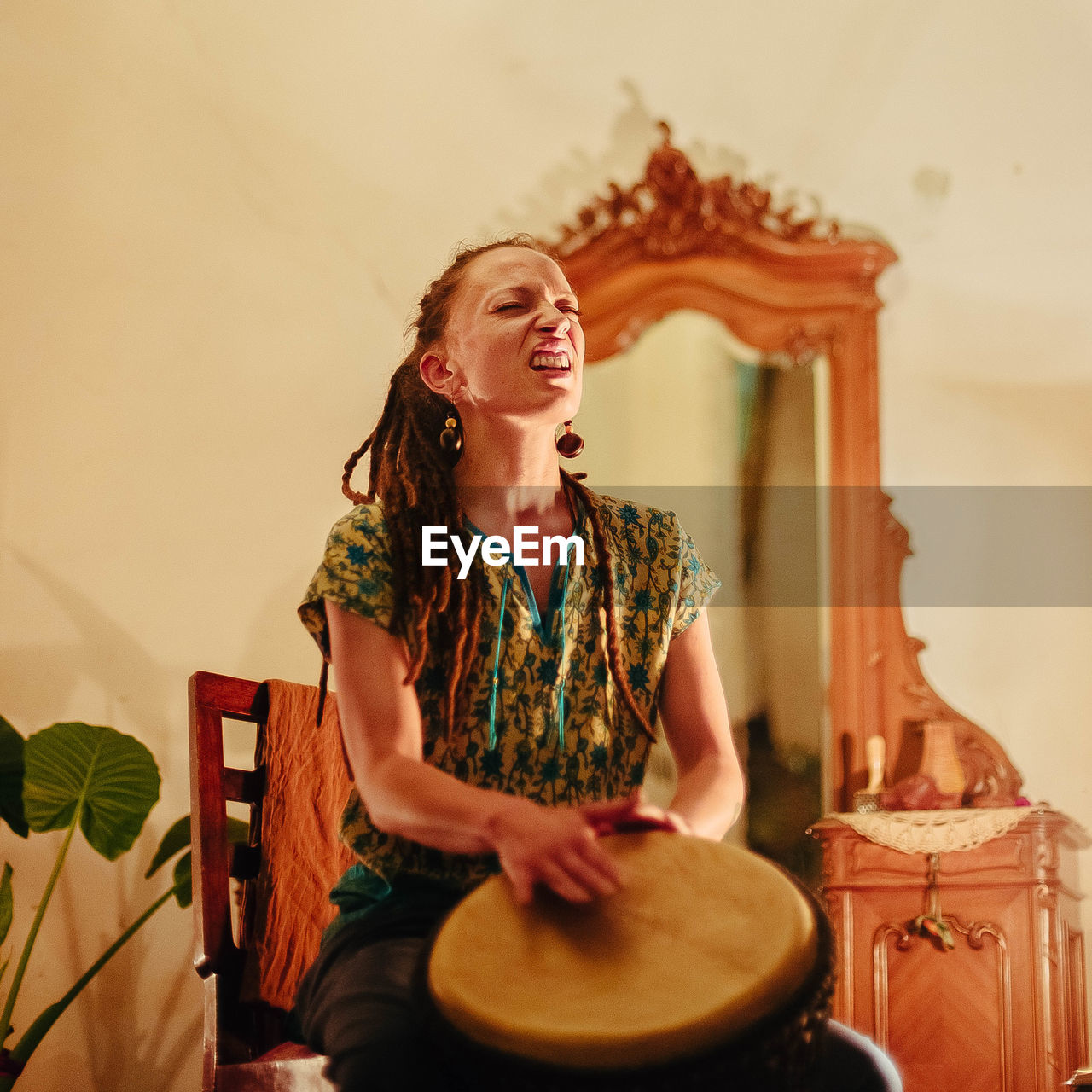 SMILING YOUNG WOMAN PLAYING AT HOME