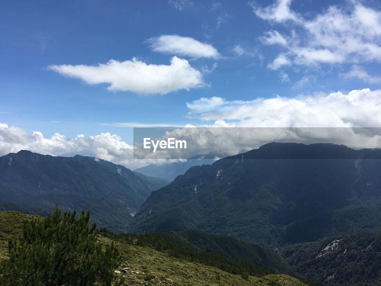 SCENIC VIEW OF MOUNTAINS AGAINST CLOUDY SKY