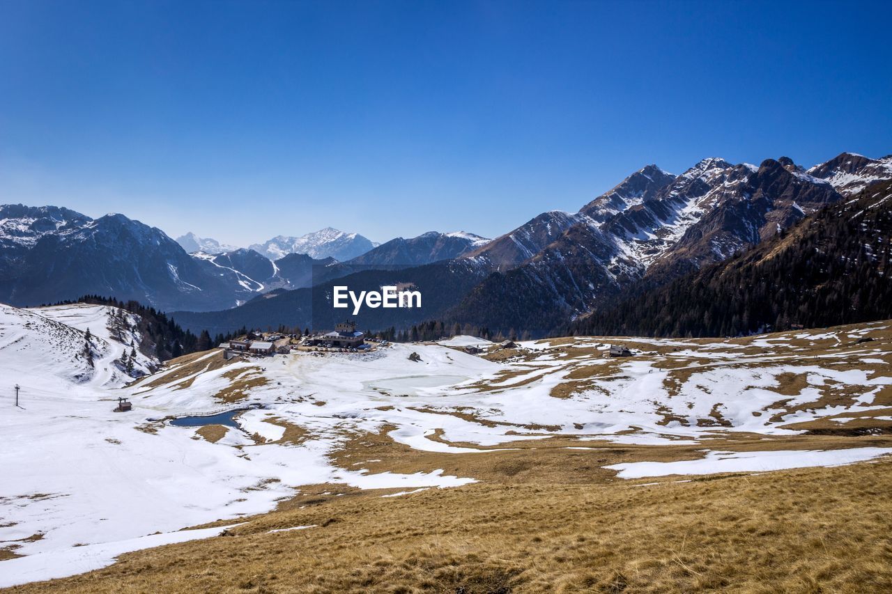 Scenic view of snowcapped mountains against clear blue sky