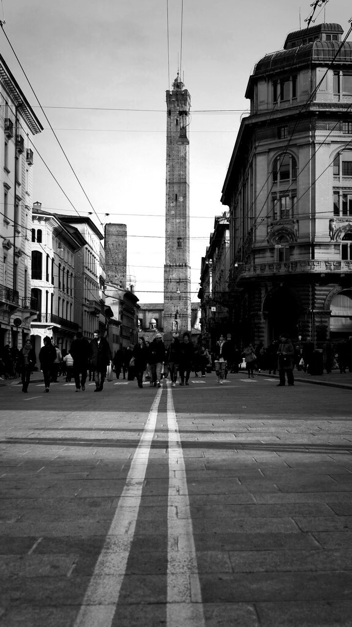 Street leading towards asinelli tower against sky