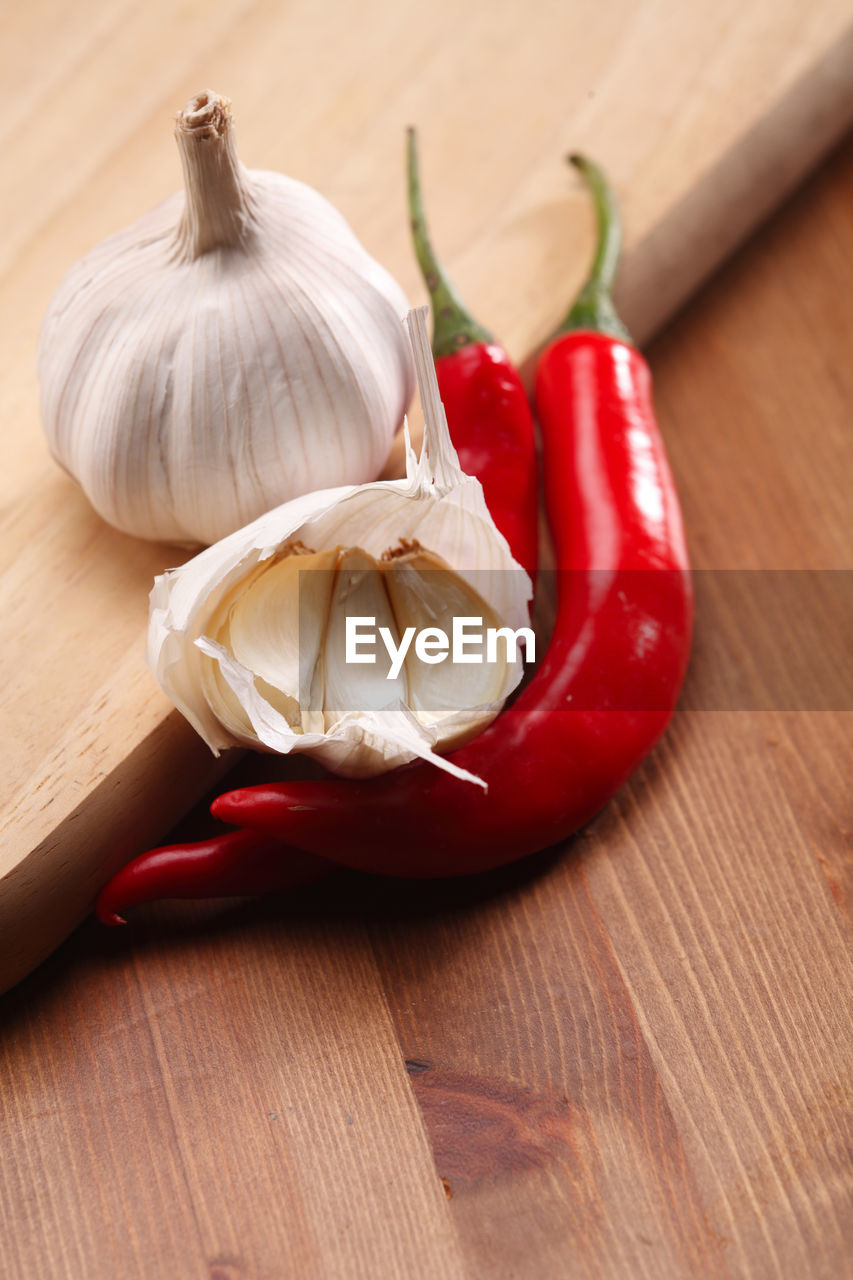 High angle view of red chili peppers and garlic on table