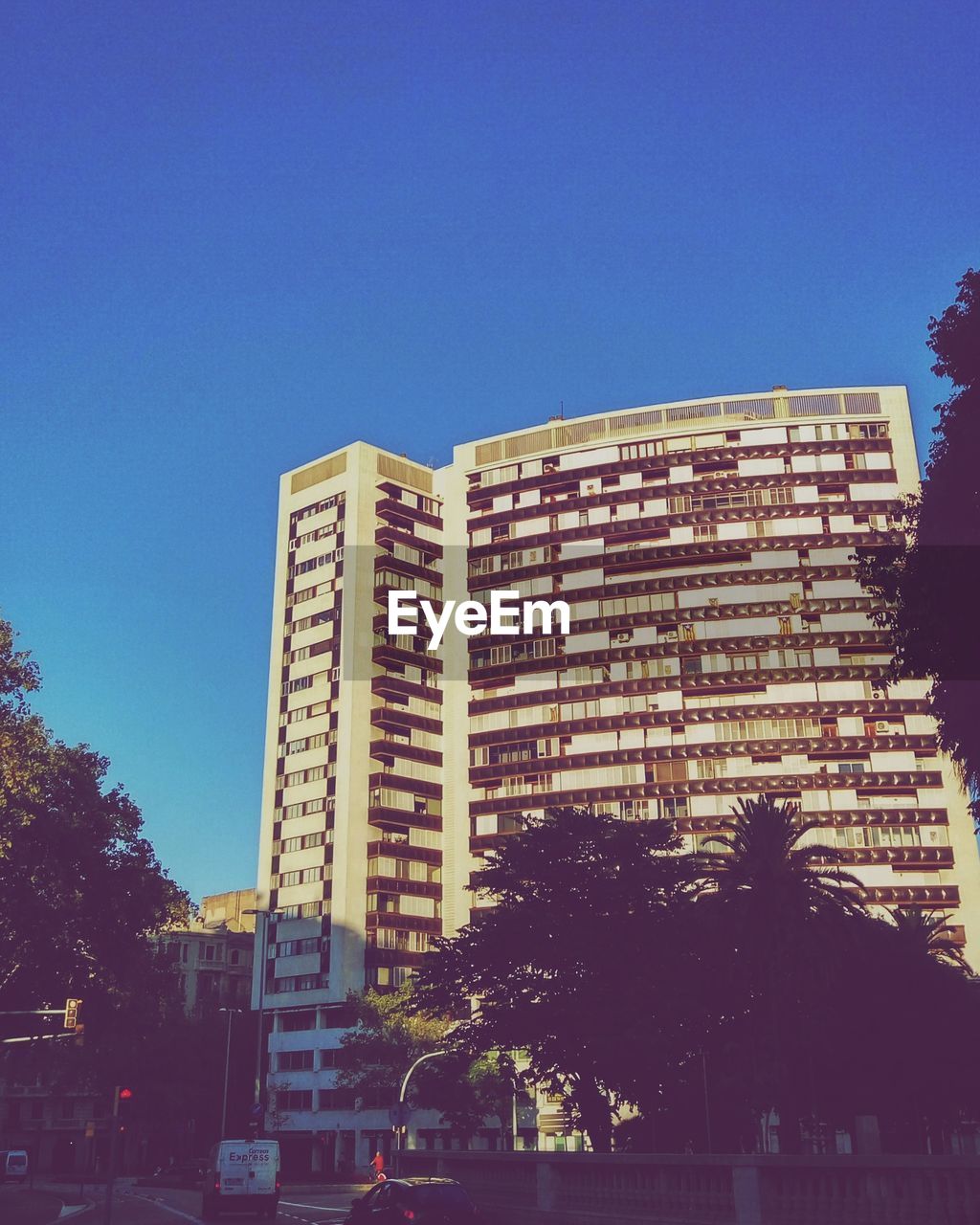 LOW ANGLE VIEW OF OFFICE BUILDING AGAINST BLUE SKY