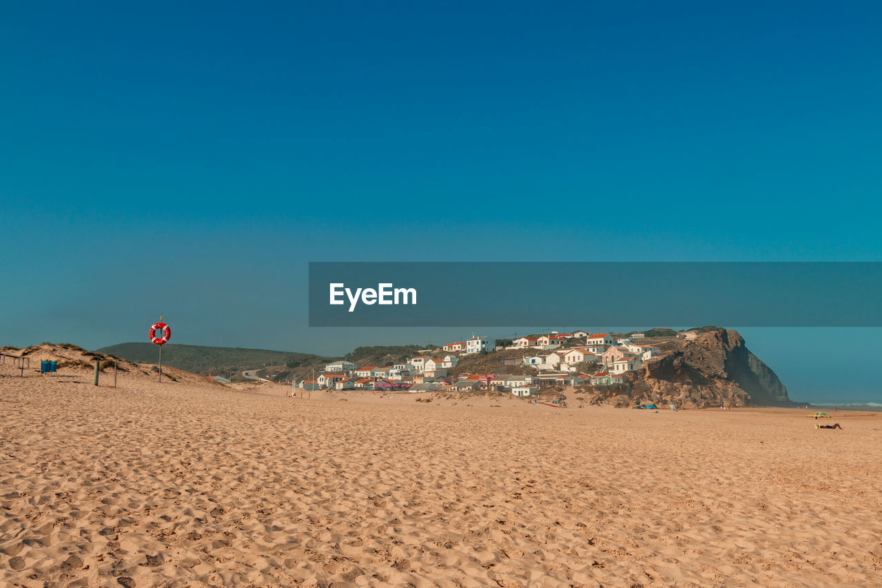 Scenic view of beach against clear blue sky