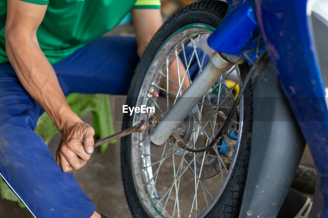 Close-up of hand holding bicycle in park