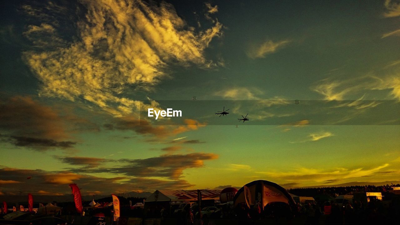 SILHOUETTE OF AIRPLANE FLYING OVER CLOUDS