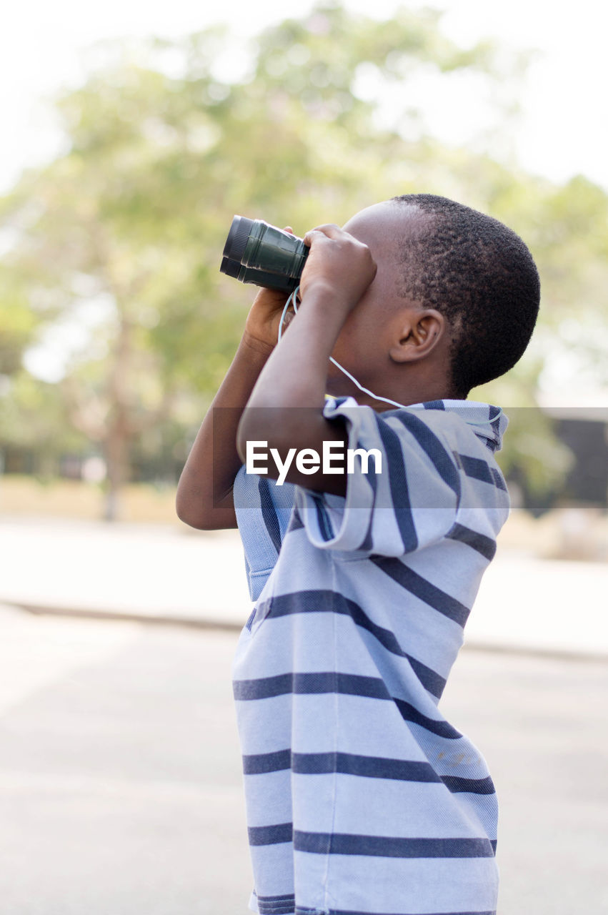 Child looks through the binoculars to search his mark.