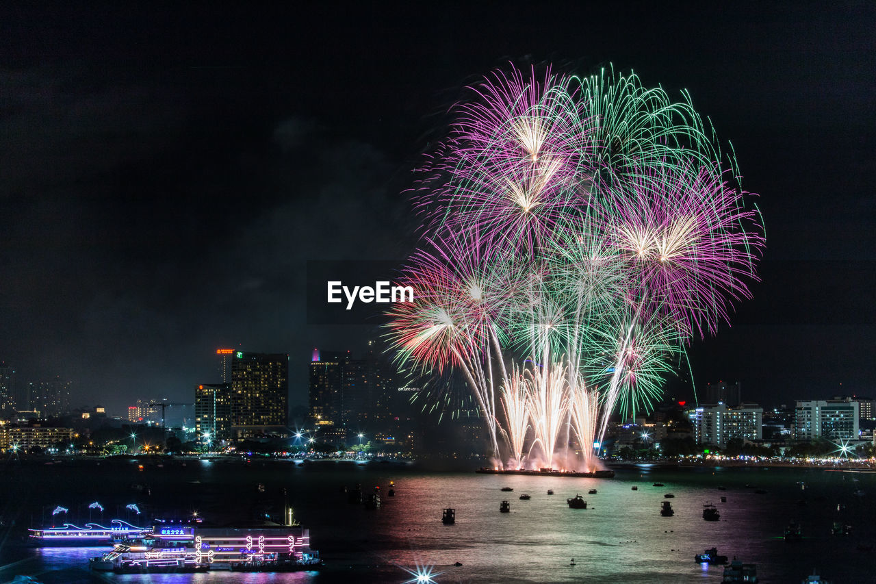 Firework display over river at night