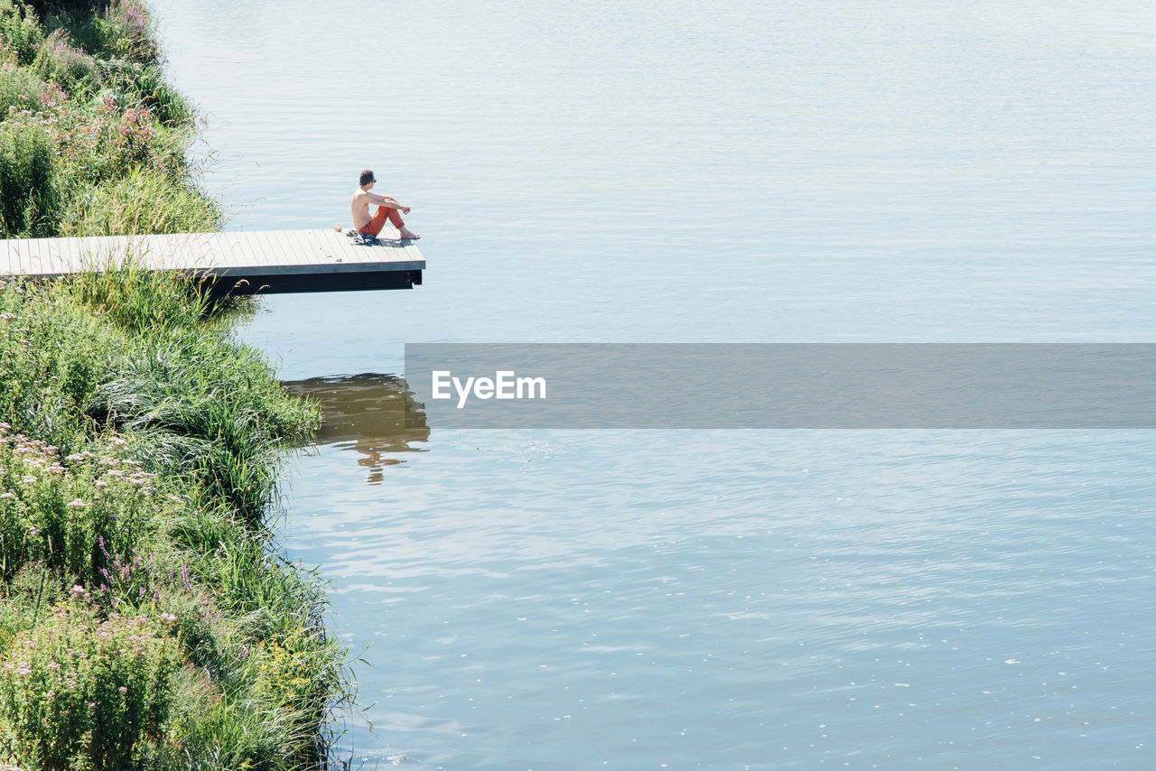 Man sitting by lake