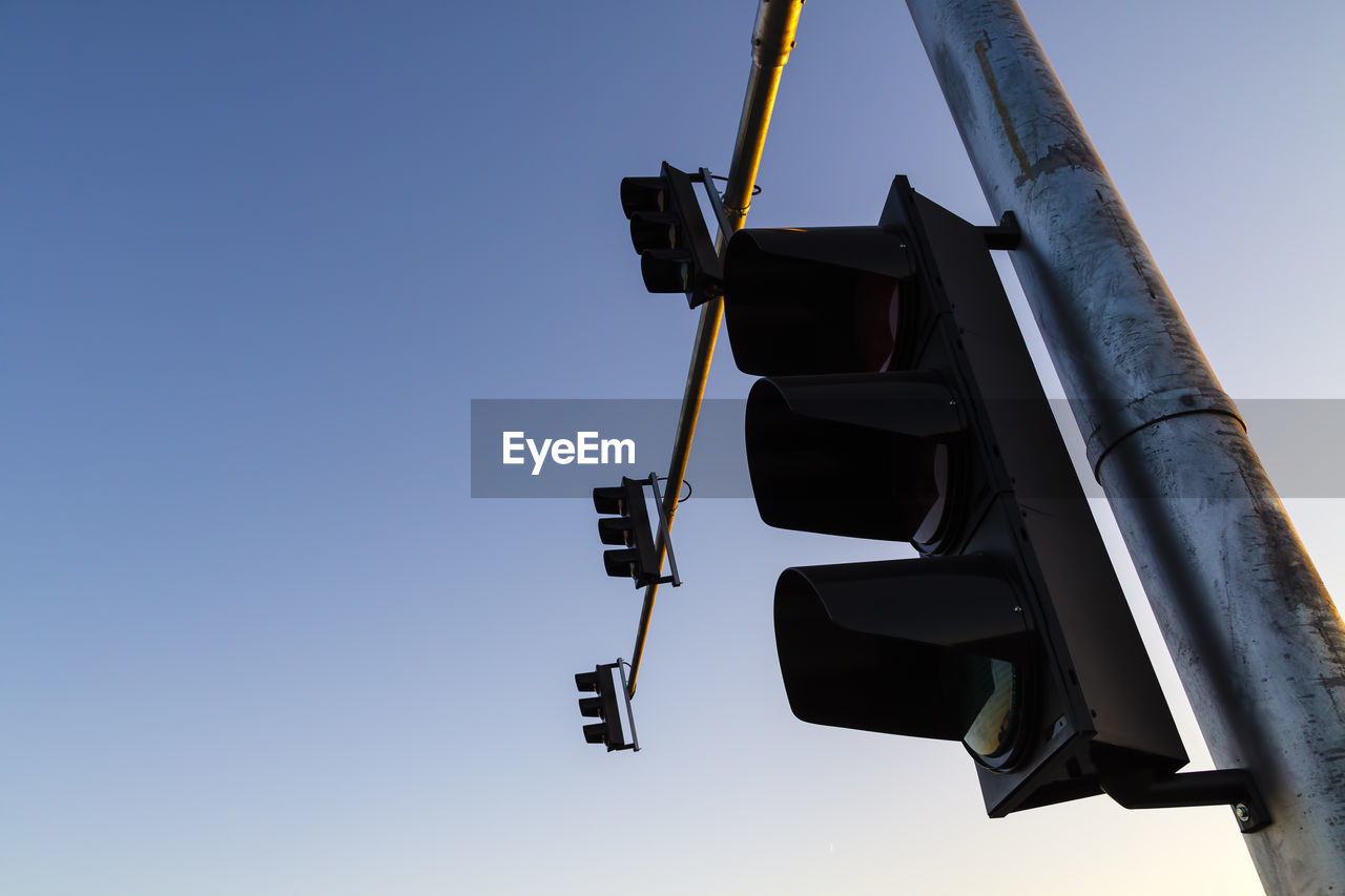 LOW ANGLE VIEW OF ROAD SIGNAL AGAINST CLEAR SKY