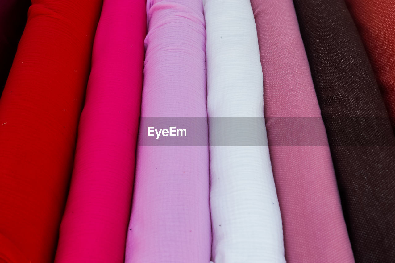 Close up view on samples of cloth and fabrics in different colors found at a fabrics market.