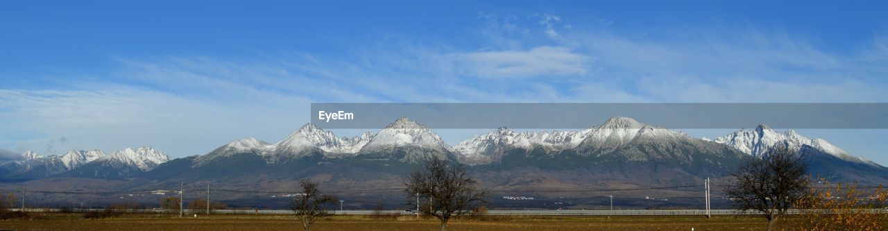 Scenic view of landscape with snowcapped mountains against sky