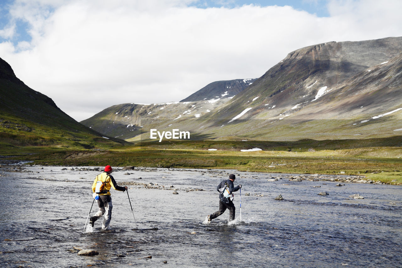 Hikers crossing mountain river