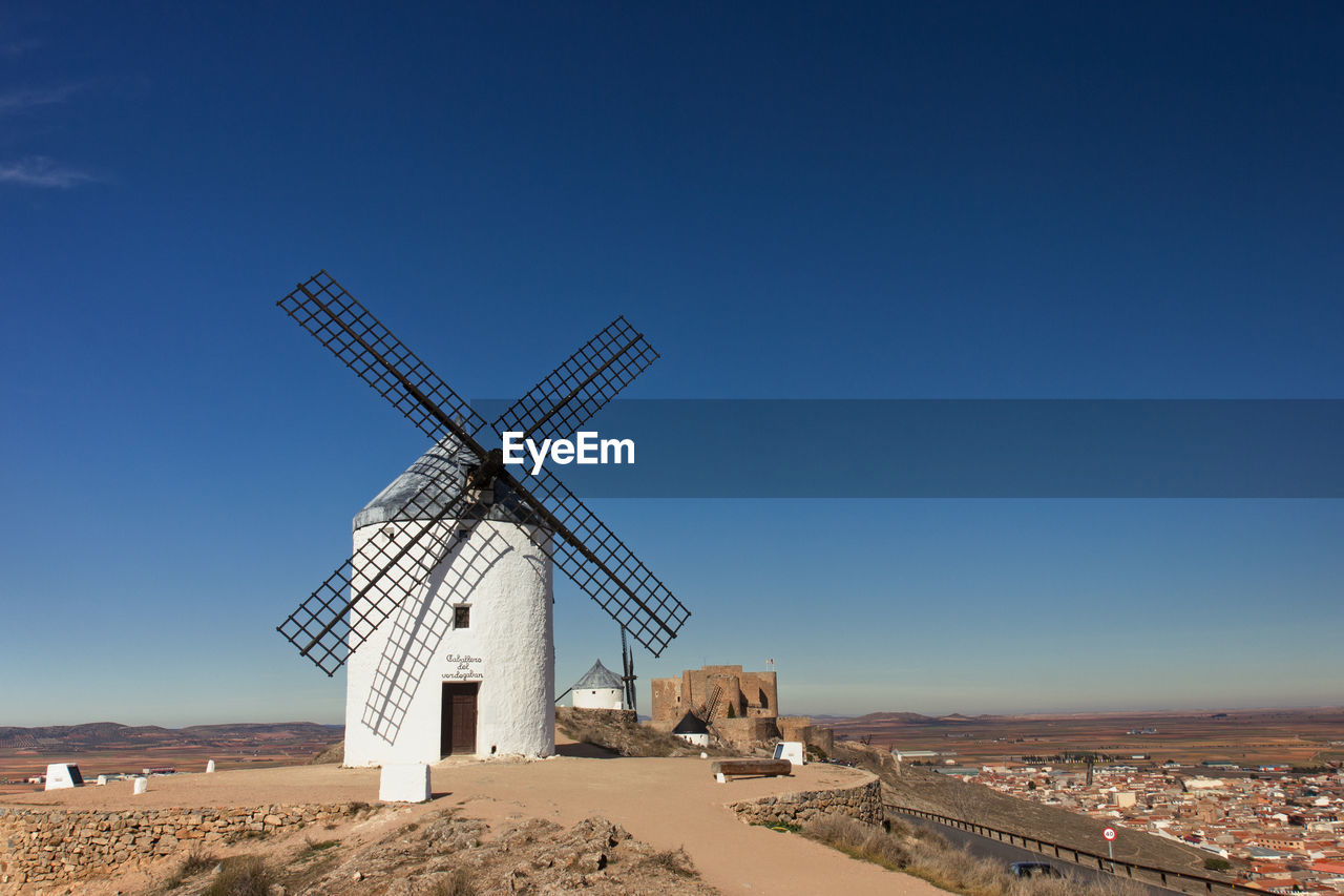 TRADITIONAL WINDMILL ON LANDSCAPE AGAINST BLUE SKY