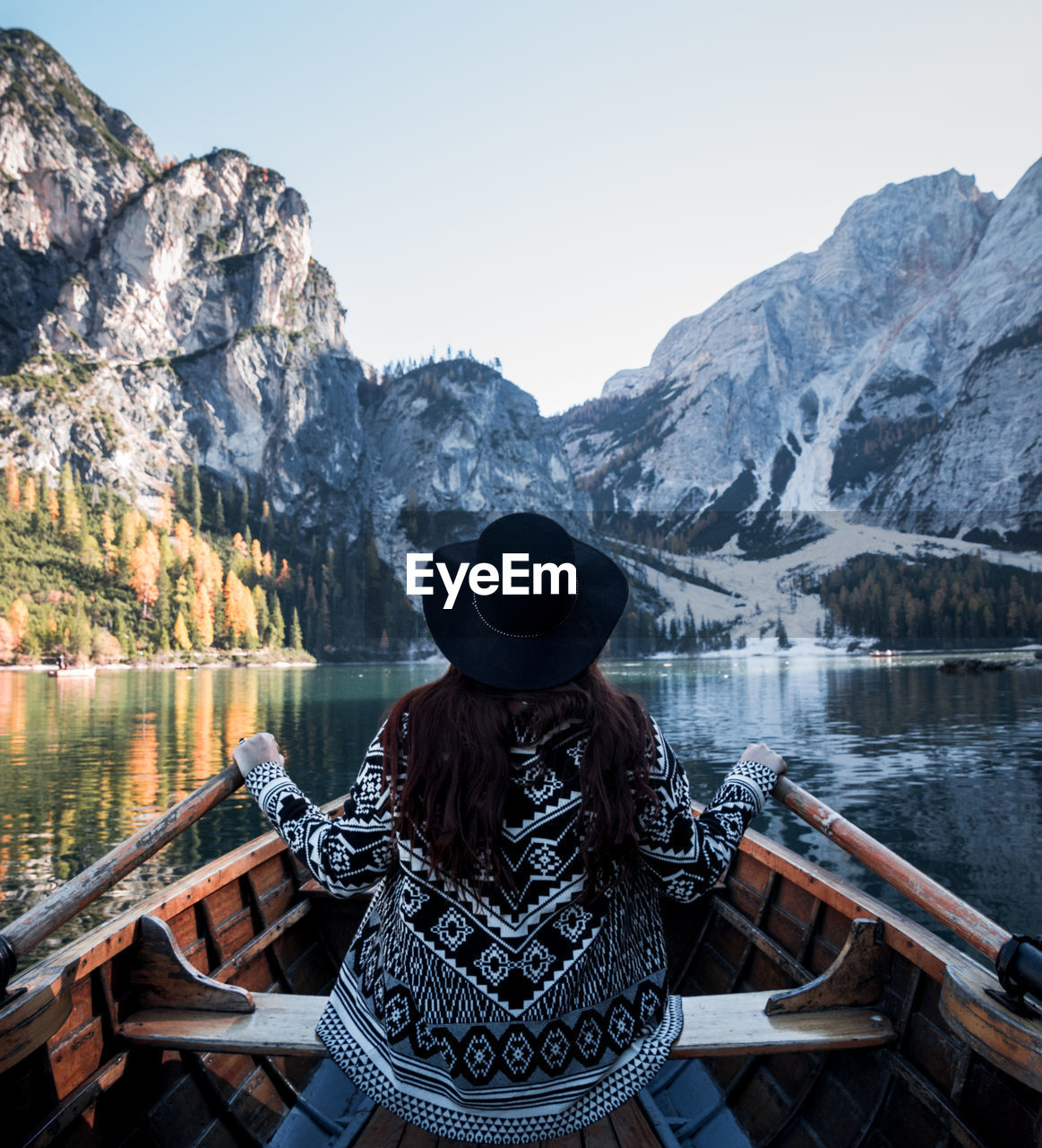 Woman looking at lake against mountain range