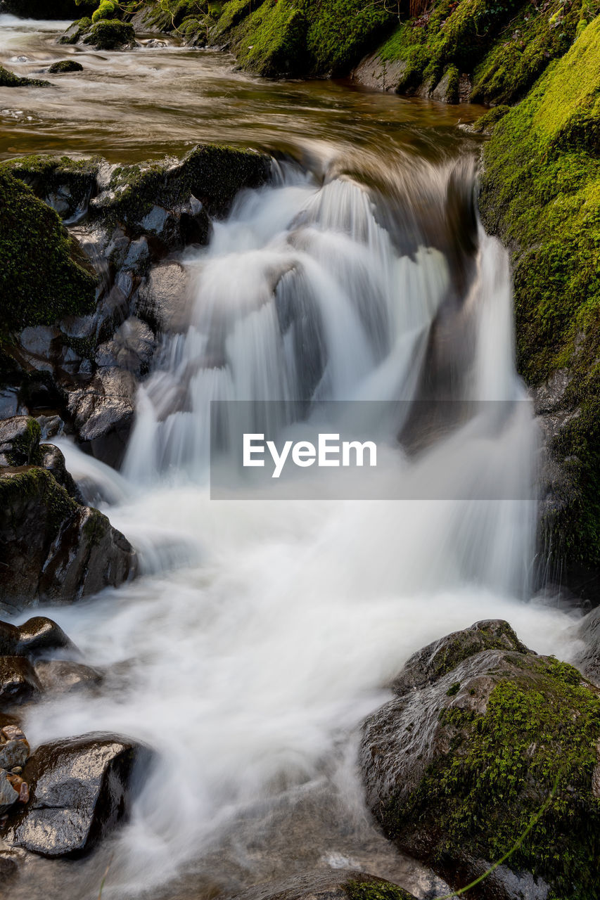 Long exposure of a waterfall flowing over rocks at watersmeet in exmoor national park