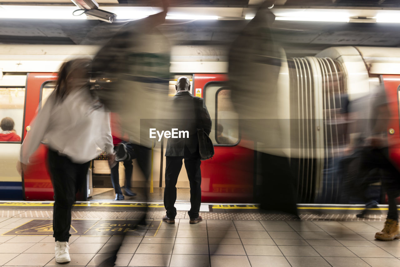 Businessman surrounded by commuters at subway station