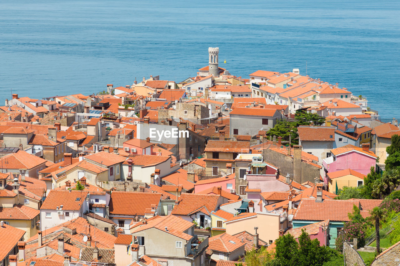 HIGH ANGLE VIEW OF TOWNSCAPE BY SEA AGAINST SKY