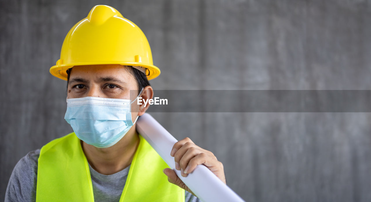 PORTRAIT OF MAN WORKING WITH YELLOW UMBRELLA