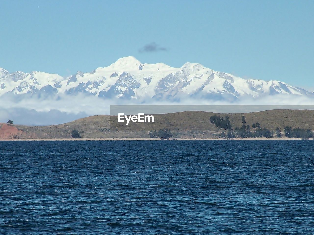 SCENIC VIEW OF SEA BY SNOWCAPPED MOUNTAIN AGAINST SKY