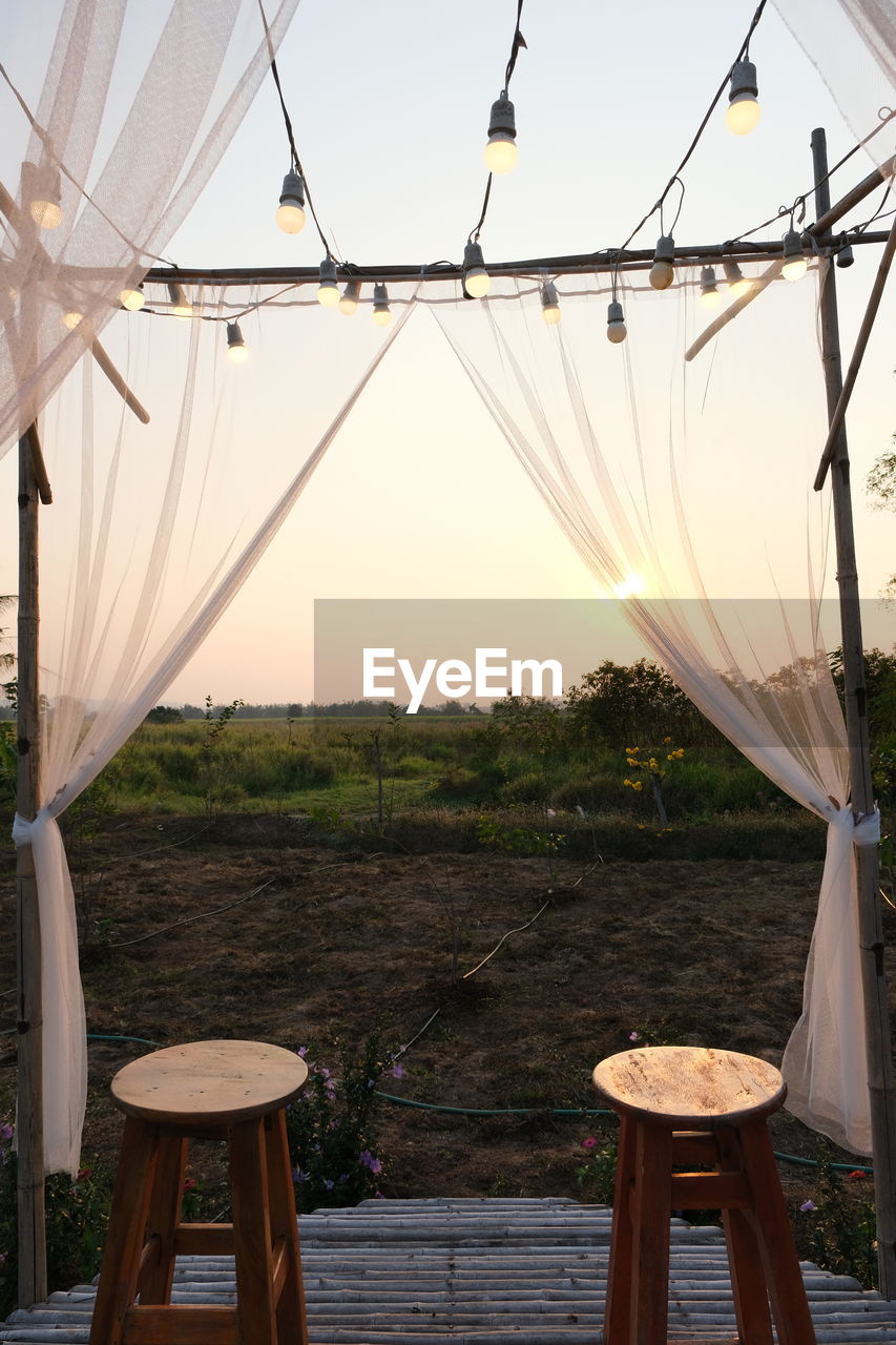 EMPTY CHAIRS AND TABLES AGAINST CLEAR SKY