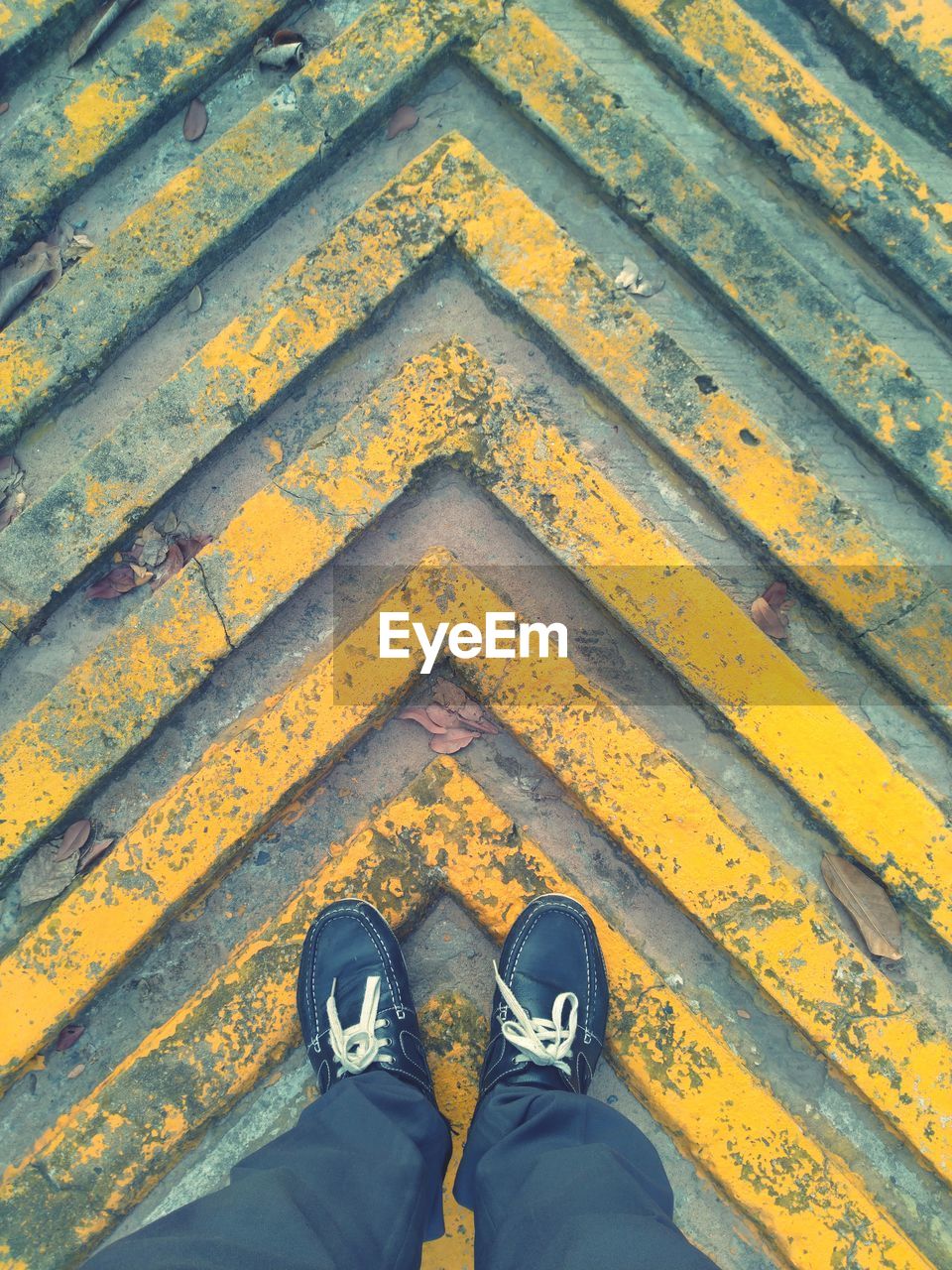 Low section of man standing on patterned footpath