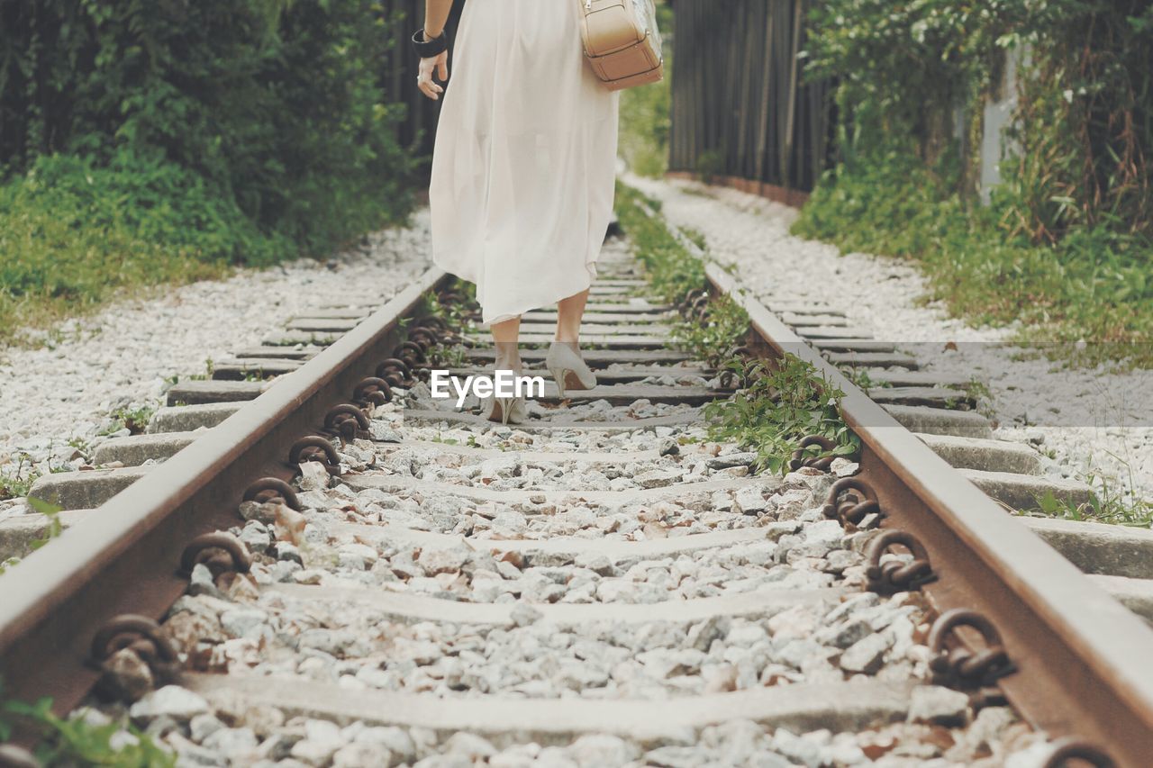 Woman walking on railroad tracks