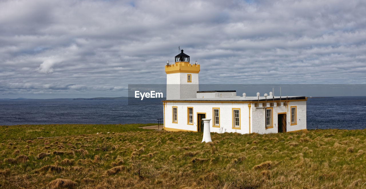 LIGHTHOUSE AMIDST SEA AGAINST SKY