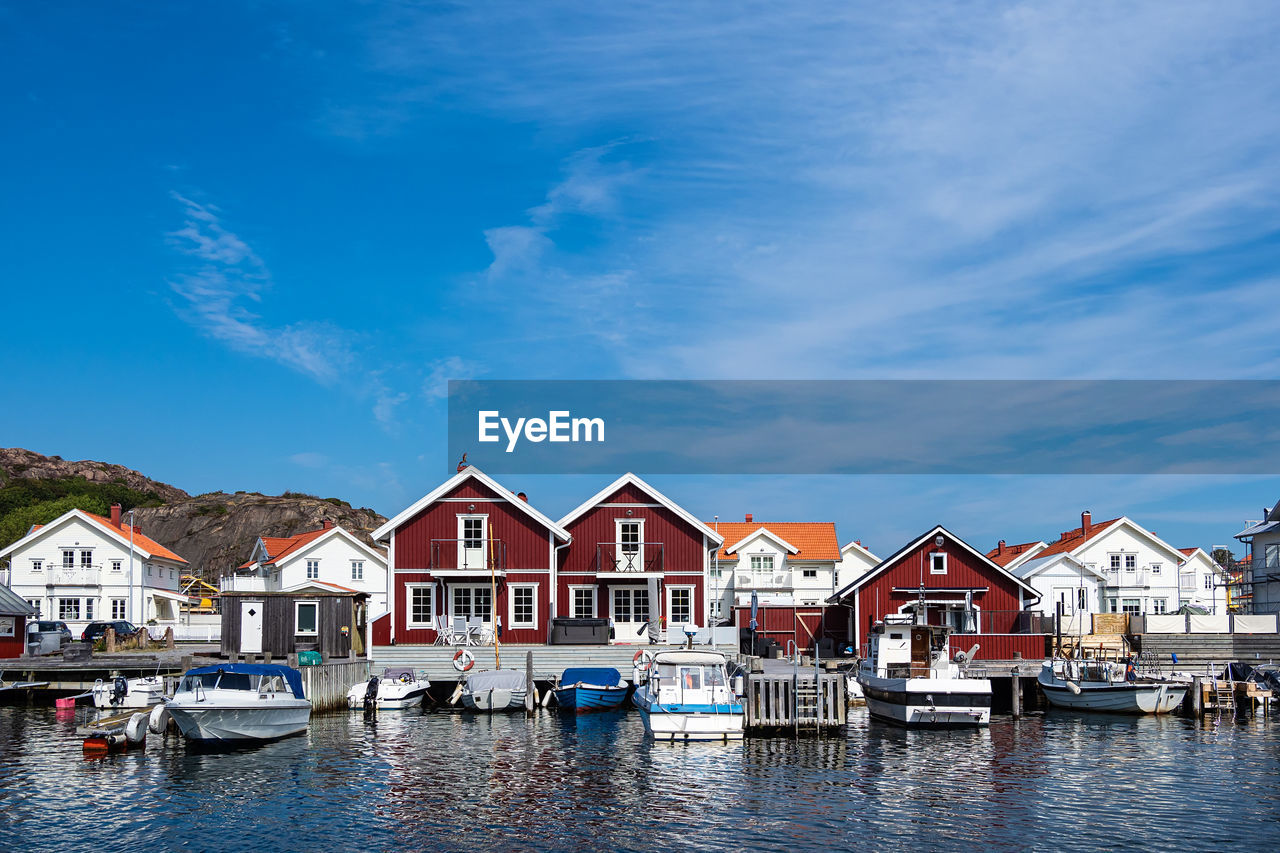 BOATS MOORED AT HARBOR AGAINST BUILDINGS