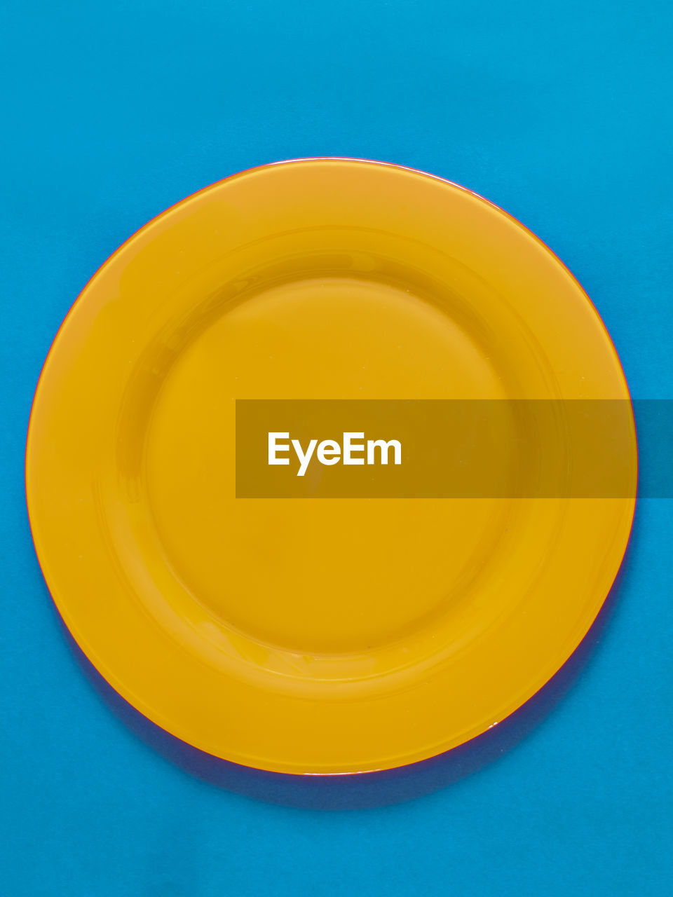 Empty yellow plate on blue background