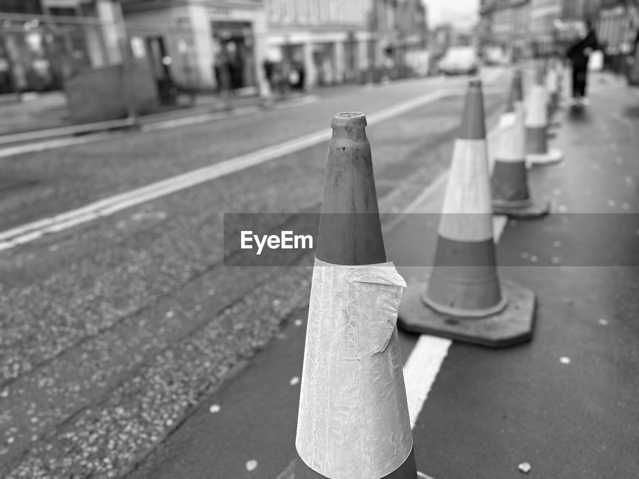road, city, black and white, cone, street, monochrome photography, monochrome, traffic cone, focus on foreground, black, transportation, architecture, white, day, sign, no people, lane, outdoors, symbol, close-up, protection, city street