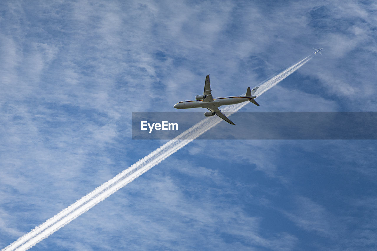 Low angle view of airplane against cloudy sky