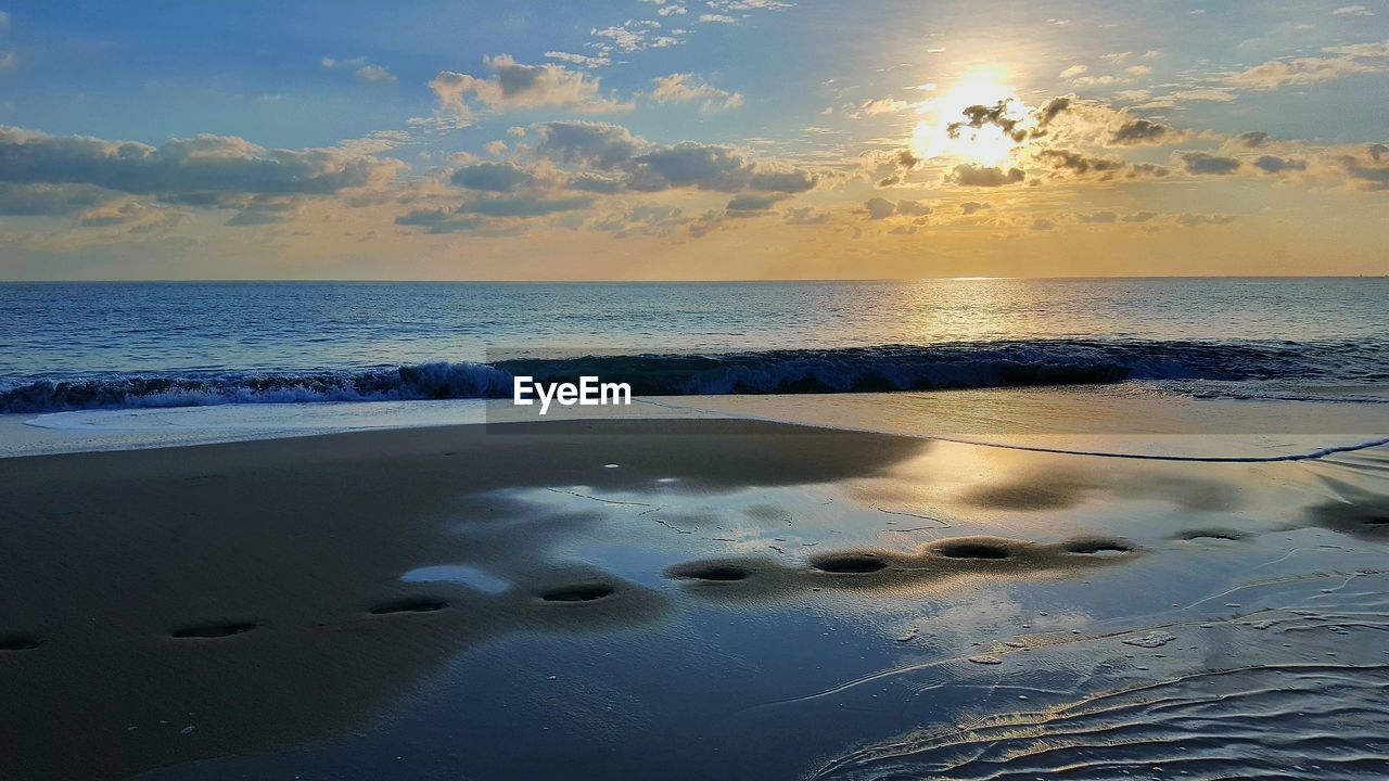 SCENIC VIEW OF BEACH AGAINST SKY DURING SUNSET