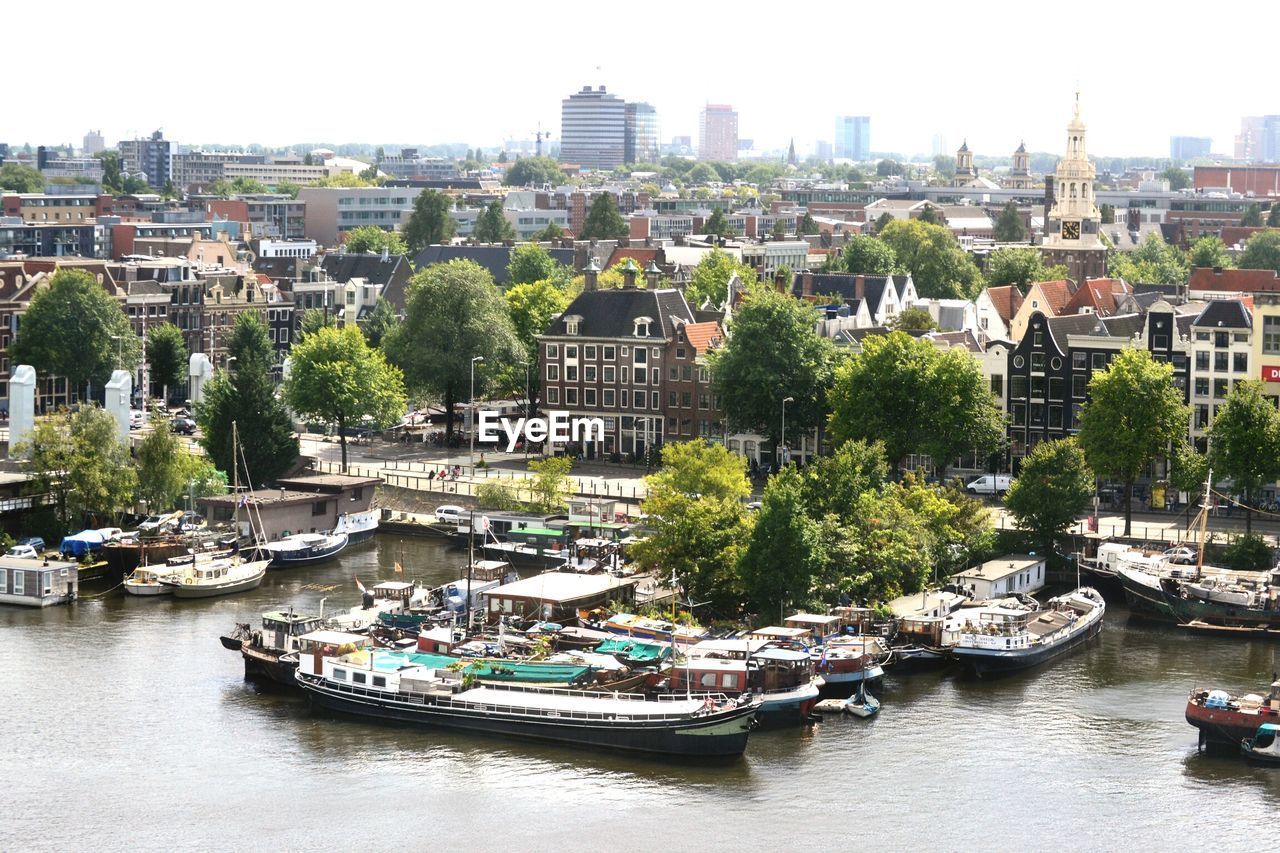 Boats in river with city in background