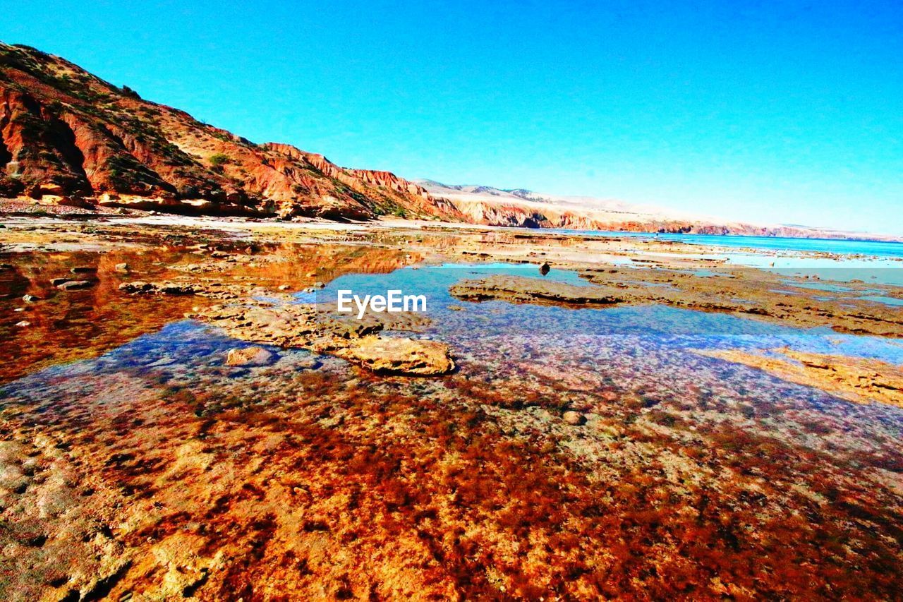 Scenic view of calm lake against blue sky