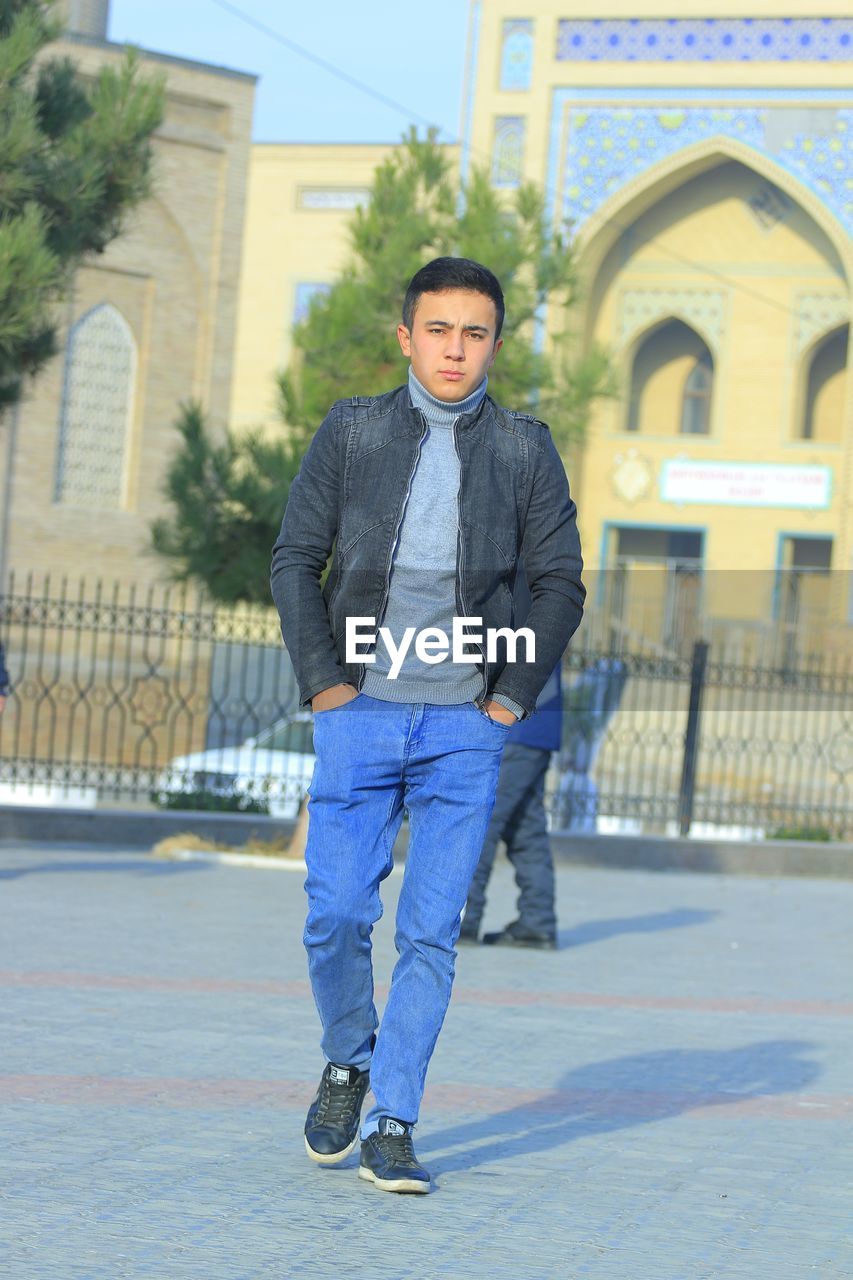 Portrait of young man standing in city