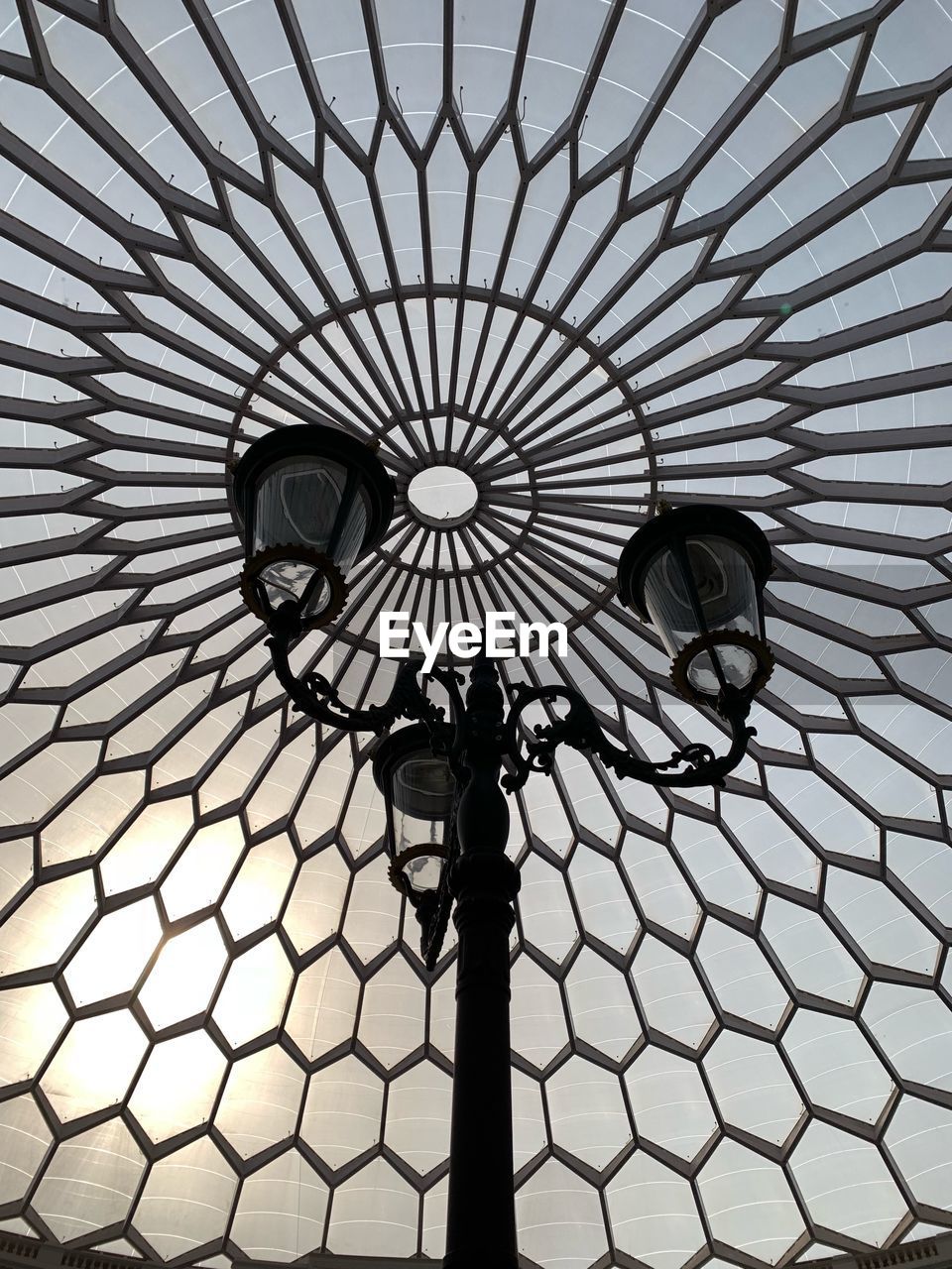 LOW ANGLE VIEW OF ILLUMINATED CHANDELIER ON STREET