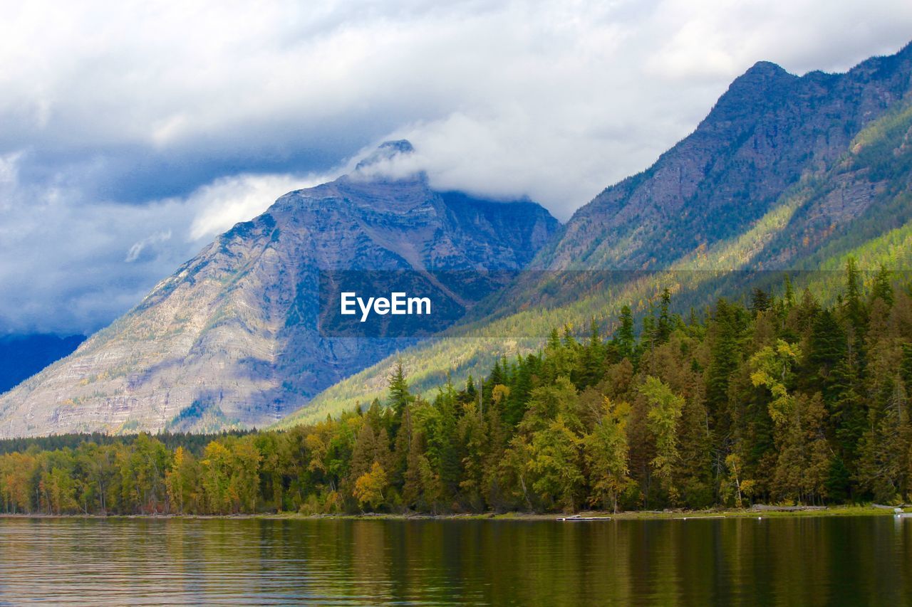 Scenic view of lake by mountains against sky