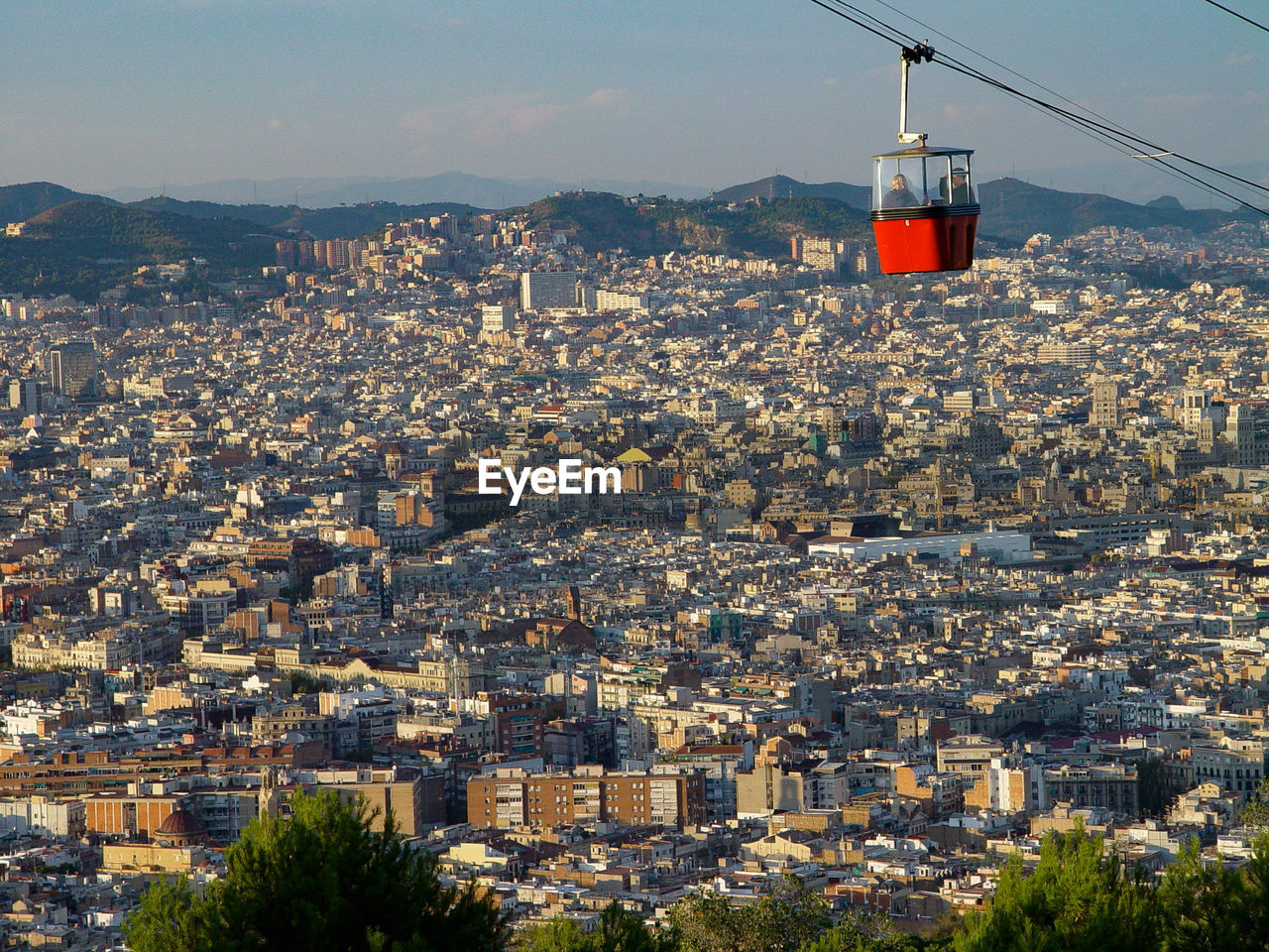 Cable car over cityscape against sky