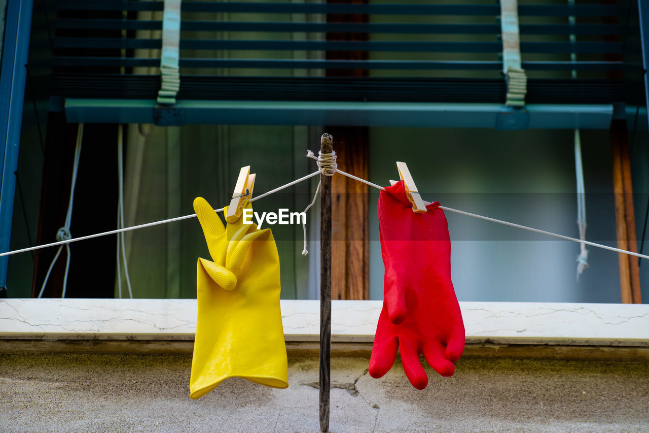 CLOTHES HANGING ON CLOTHESLINE AGAINST WINDOW