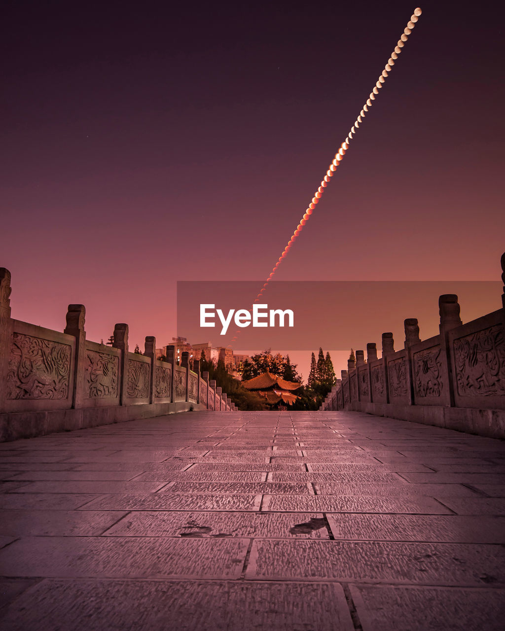 Bridge against sky during lunar eclipse at night