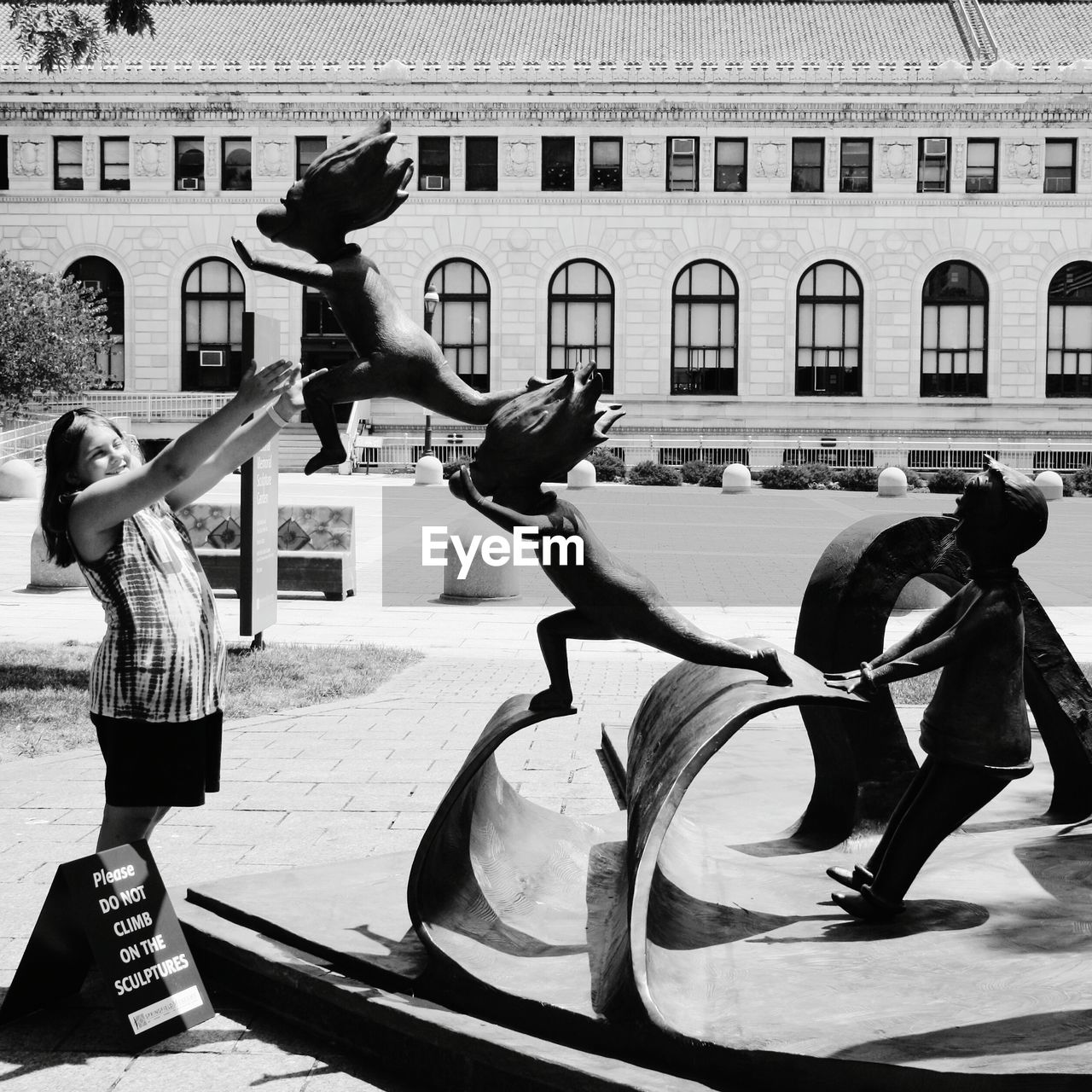 Happy woman reaching for sculpture