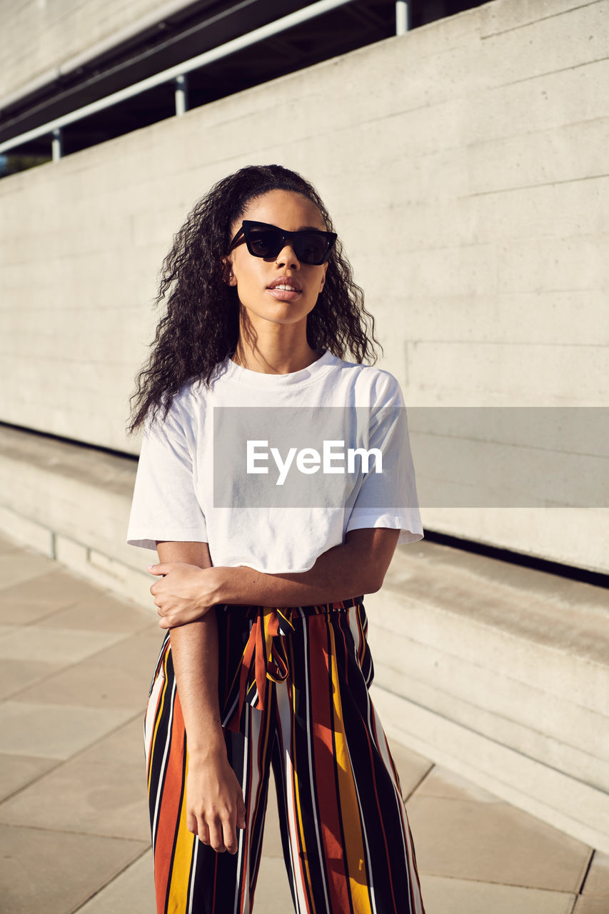 PORTRAIT OF YOUNG WOMAN WEARING SUNGLASSES