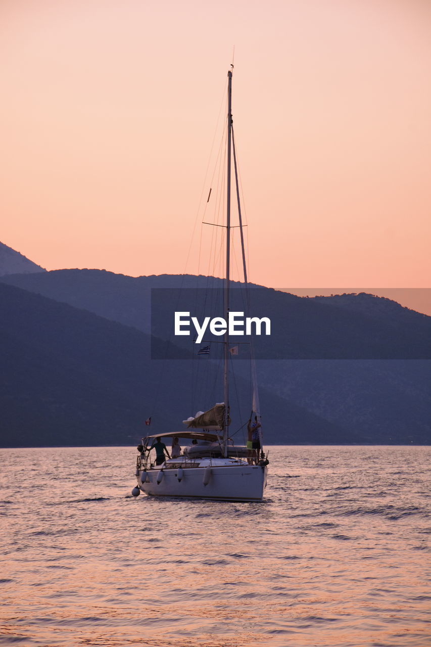 SAILBOAT SAILING IN SEA AGAINST SKY DURING SUNSET