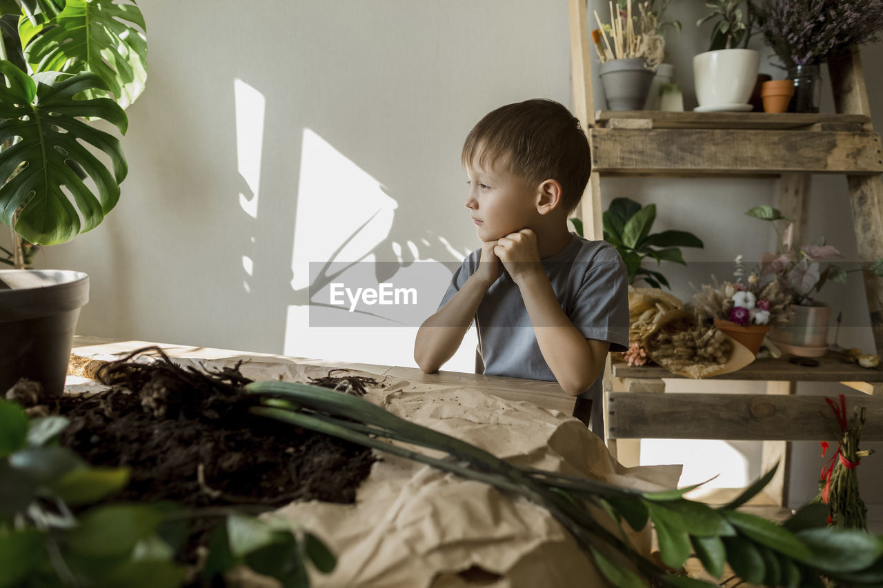 Boy sitting at table in living room