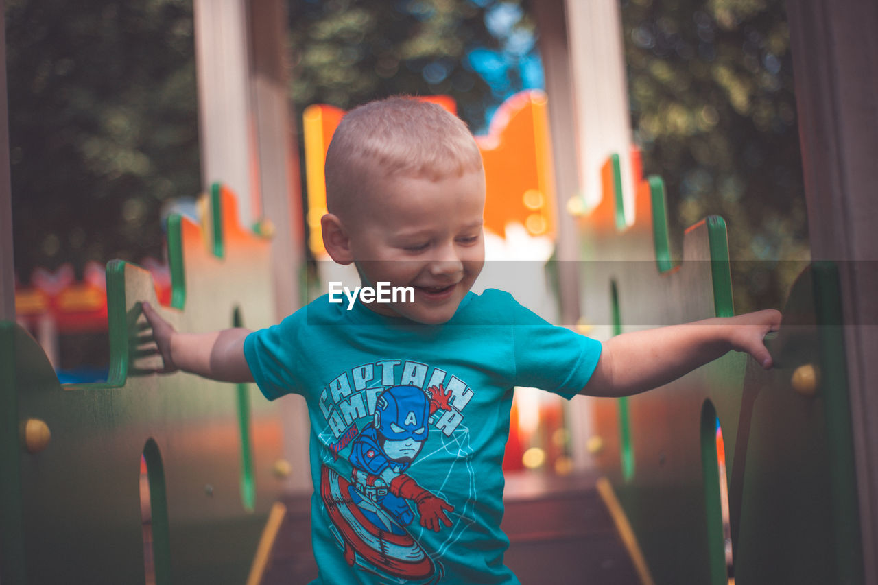 Cute boy standing on outdoor play equipment at playground