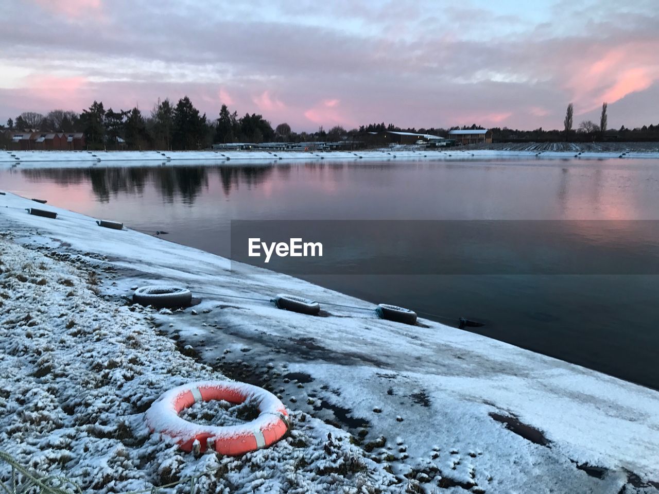 Scenic view of lake in winter at sunset